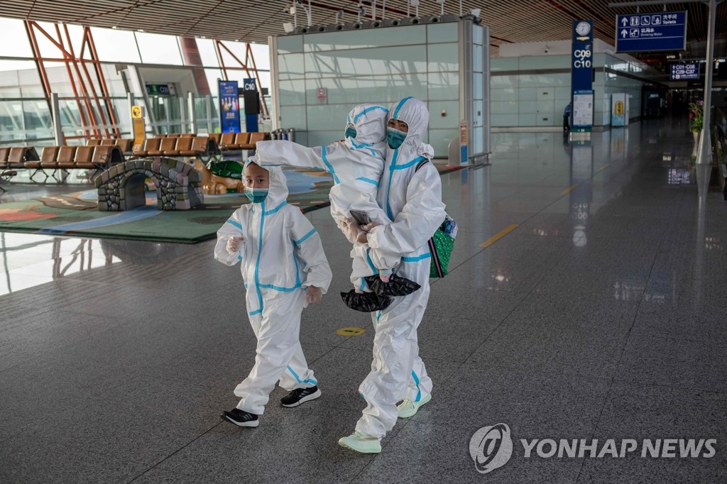 베이징 공항의 코로나19 방호복 착용 탑승객들
