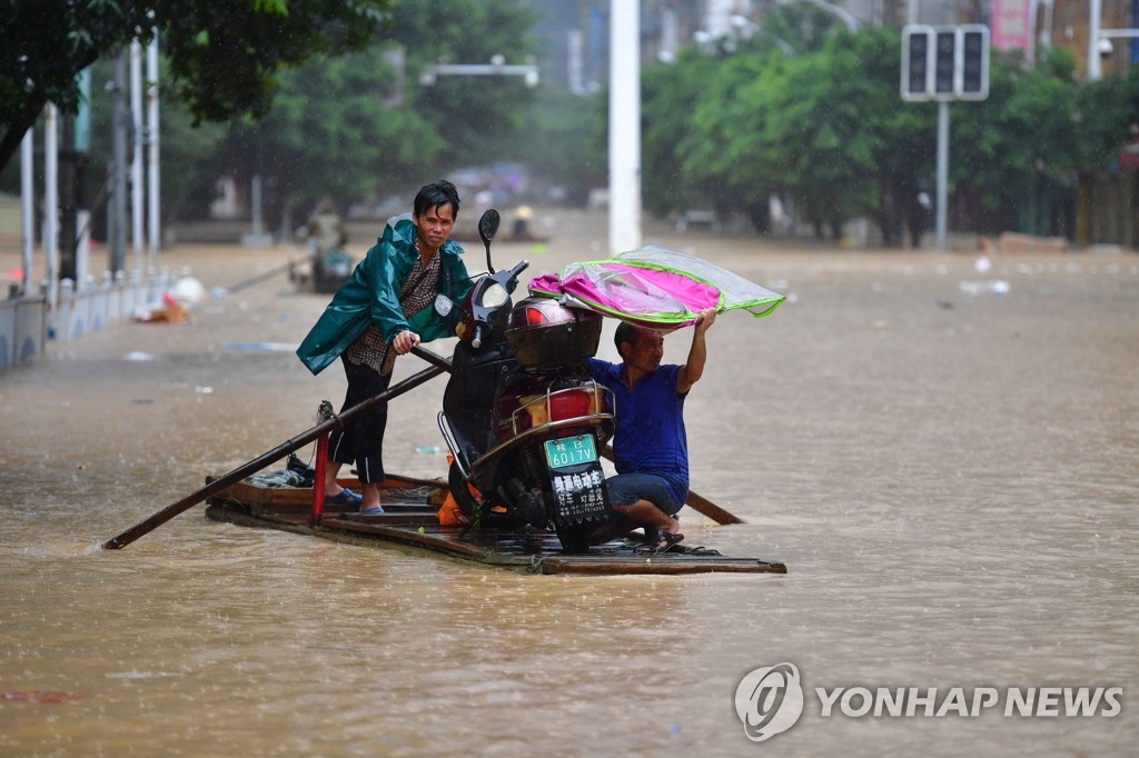뗏목 타고 이동하는 중국 폭우 피해 주민