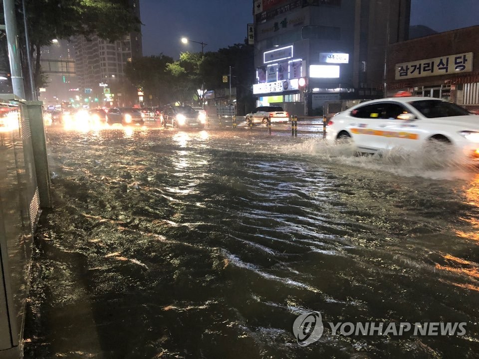 Cars plow through partially flooded roads in Busan Cars plow through partially flooded roads in Busan