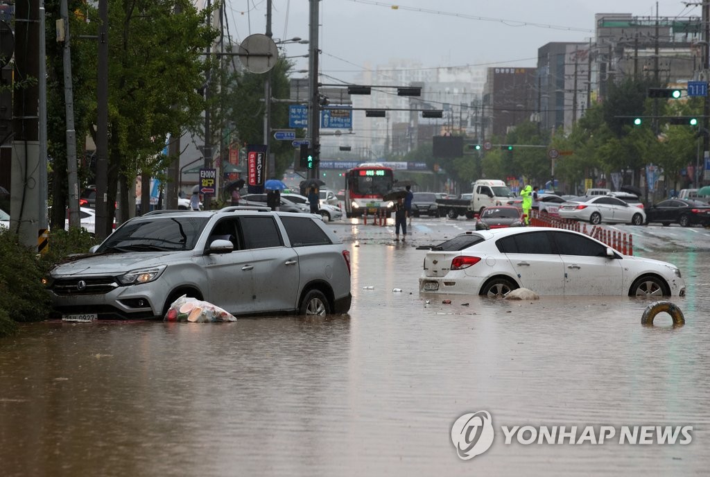 Cars are stranded on a flooded road in the southern city of Gwangju on Aug. 8, 2020. (Yonhap)