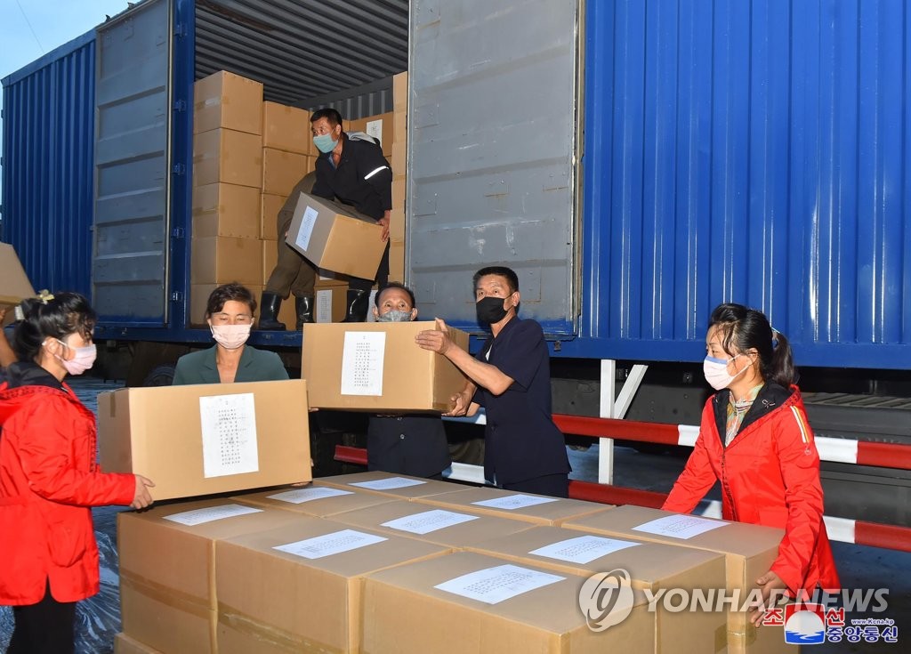 북한 간부들, 수재민 구호물품 전달