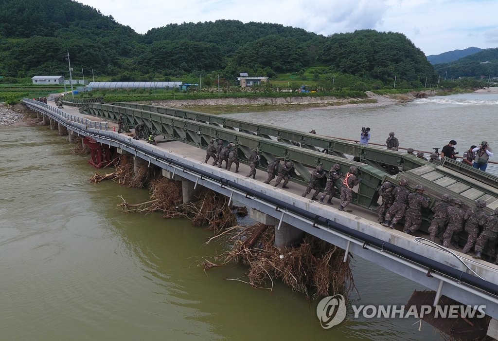 Los soldados construyen un puente provisional para los residentes afectados por las inundaciones Los soldados construyen un puente provisional para los residentes afectados por las inundaciones