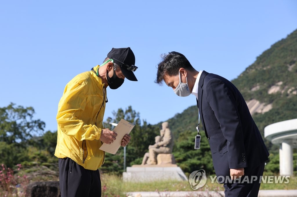 This photo shows Lee Rae-jin (L), the elder brother of the slain fisheries official, delivering his nephew's letter addressed to President Moon Jae-in, to a Cheong Wa Dae official outside the presidential office on Oct. 8, 2020. (Yonhap)