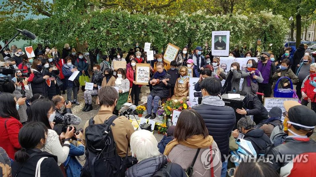 Activists and citizens hold a rally in front of the Statue of Peace near Mitte district office in Berlin on Oct. 13, 2020, calling for the withdrawal of the district office's order to remove the Statue of Peace, which symbolizes Korean victims of Japan's wartime sexual slavery. (Yonhap)