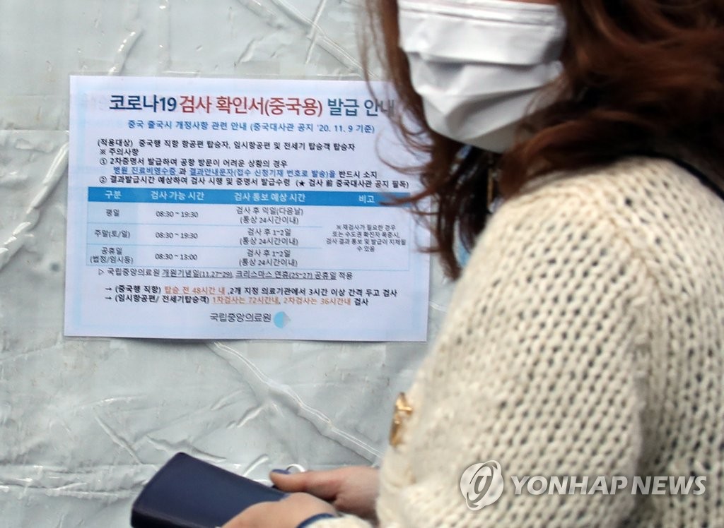 韓国から中国に渡航する人は１１日から、新型コロナウイルスの検査を２回受け、いずれも陰性であることを確認する証明書の提出が義務付けられる。国立中央医療院の専用診療所に貼り出された案内文＝１１日、ソウル（聯合ニュース）