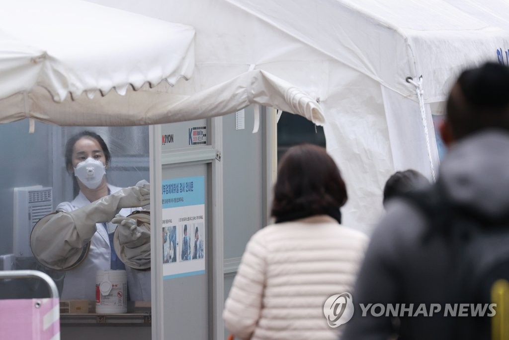 A health worker disinfects a testing site in central Seoul after conducting coronavirus tests on Nov. 20, 2020. (Yonhap)