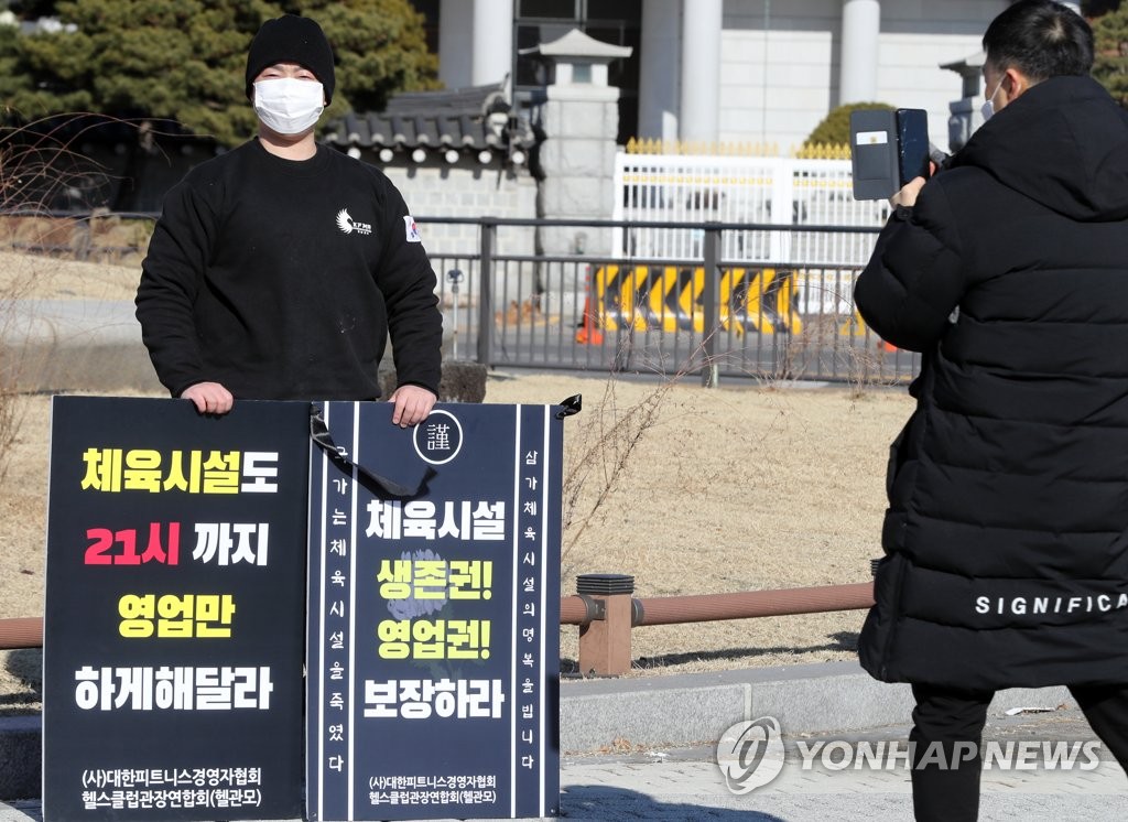 In this file photo, a member of the Korea Fitness Manager Association stages a one-person protest against the government's coronavirus restrictions in front of Cheong Wa Dae on Dec. 20, 2020, demanding sports facilities be allowed to run until 9 p.m. like other facilities including restaurants and cafes. (Yonhap)