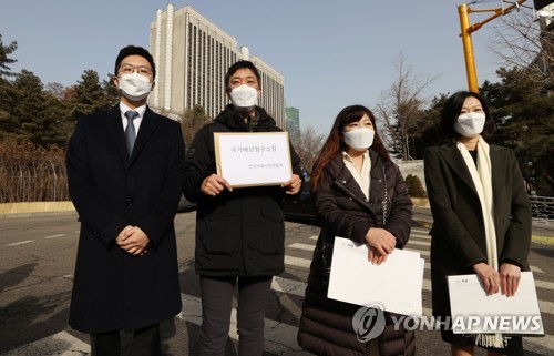Member of a cafe owners' association hold a press conference outside the Seoul Central District Court on Jan. 14, 2021, before filing a damage suit against the government at the court. (Yonhap)