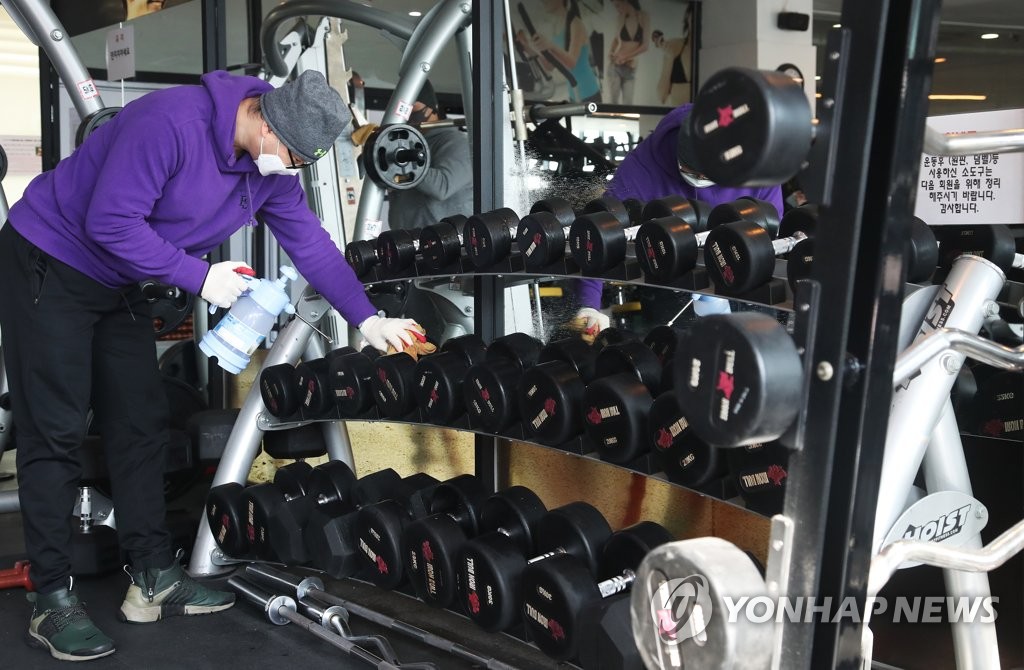 운동기구 소독하는 헬스장 직원들