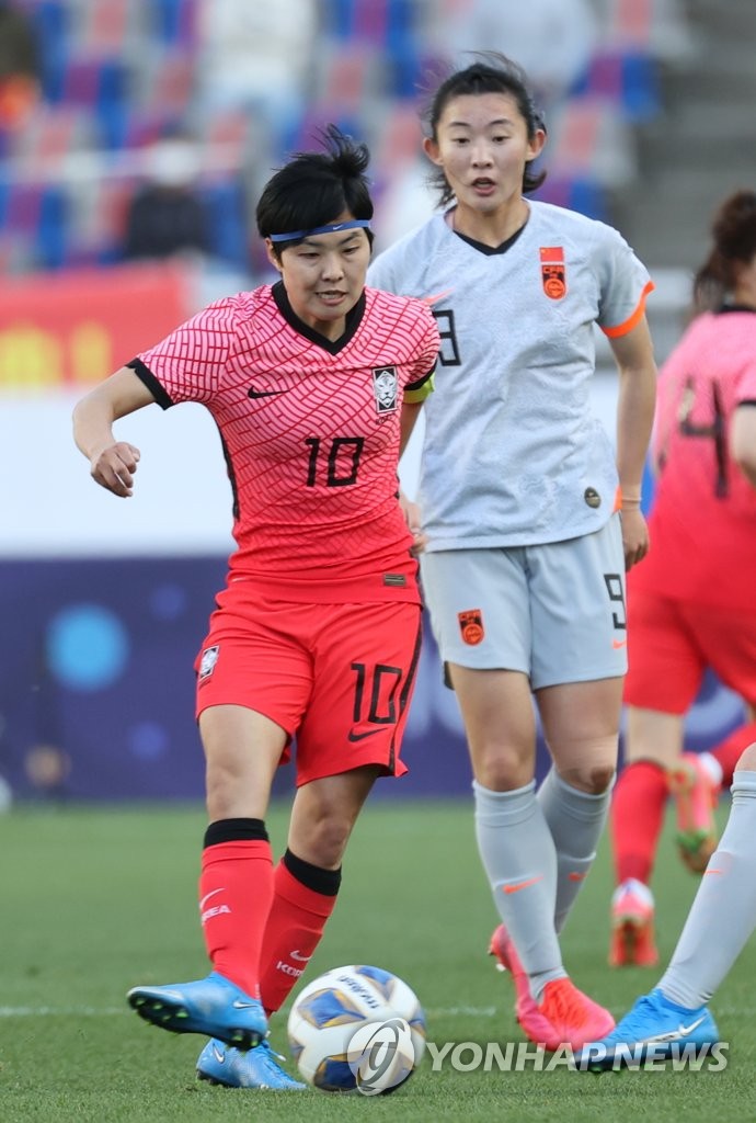 Ji So-yun of South Korea (L) dribbles the ball past Yao Wei of China during the teams' Olympic women's football qualifying match at Goyang Stadium in Goyang, Gyeonggi Province, on April 8, 2021. (Yonhap)