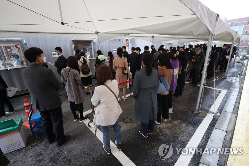 Employees at the Ministry of Justice wait for COVID-19 tests at a clinic on April 16, 2021, after the ministry reported a confirmed case at the building in Gwacheon, south of Seoul. (Yonhap)