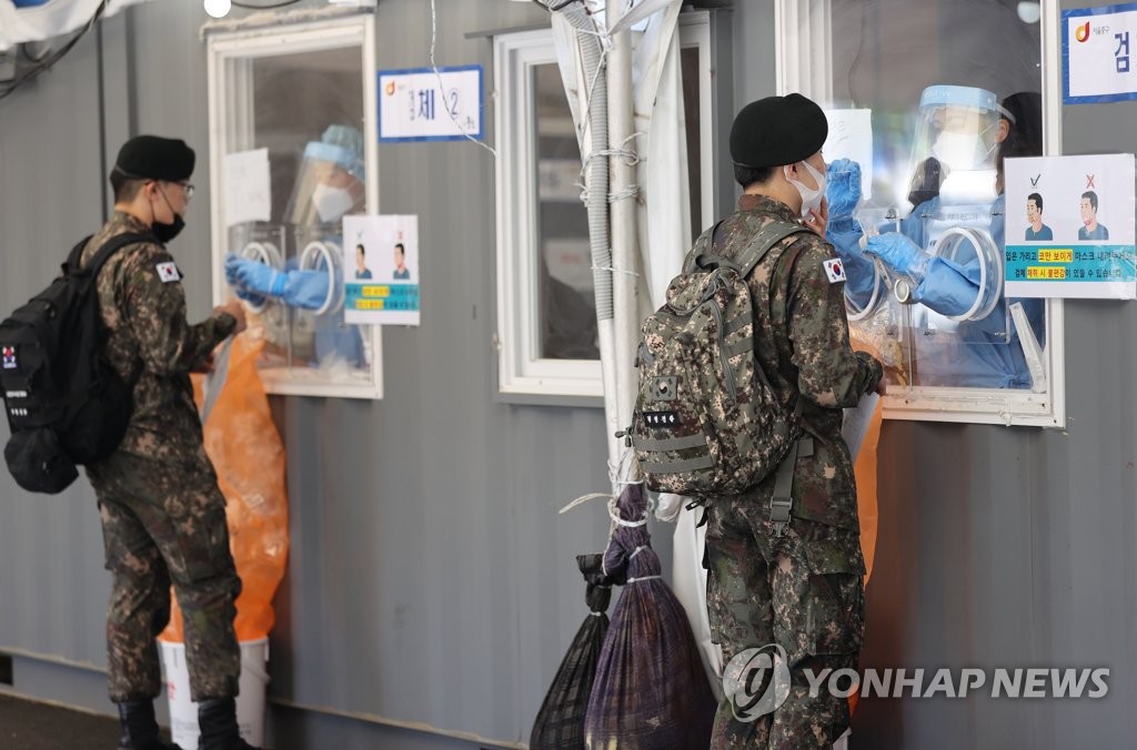 In this file photo, soldiers receive COVID-19 tests at a makeshift clinic in central Seoul on May 25, 2021. (Yonhap)
