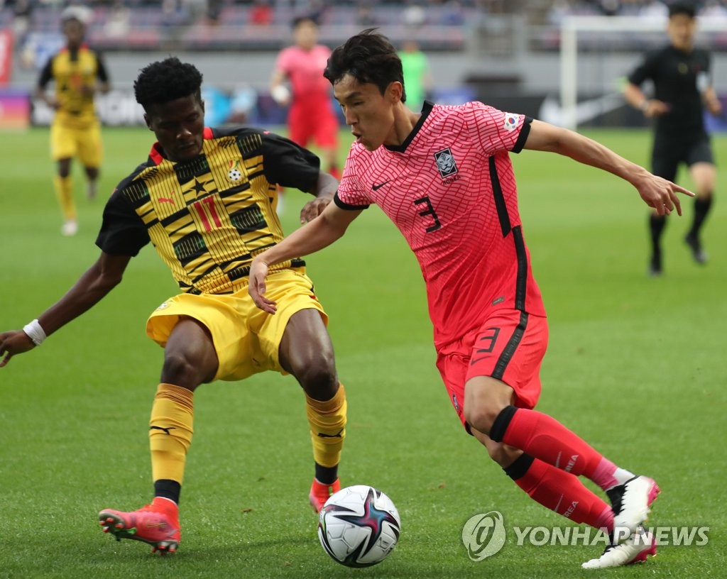 In this file photo from June 12, 2021, Kim Jin-ya (R) of the South Korean men's Olympic football team tries to dribble past Samuel Abbey-Ashie Quaye of Ghana for the ball during their teams' friendly match at Jeju World Cup Stadium in Seogwipo, Jeju Island. (Yonhap)