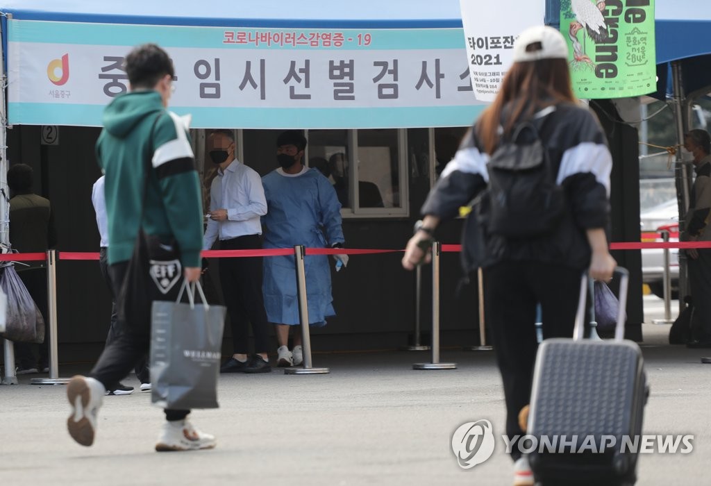 Travelers walk past a screening clinic for coronavirus tests in front of Seoul Station on Sept. 17, 2021, the eve of a five-day break for Chuseok, the Korean harvest holiday that falls on Sept. 21 this year. South Korea's daily coronavirus cases exceeded 2,000 the same day amid concerns the holiday, when tens of millions of people are expected to travel across the country, may cause further upticks in virus cases. (Yonhap)