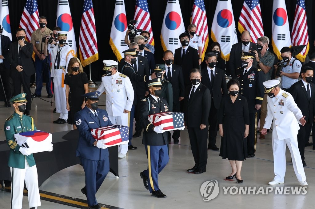 South Korean President Moon Jae-in (3rd from R), accompanied by Adm. John C. Aquilino (far R), commander of the U.S. Indo-Pacific Command, watches South Korean and U.S. honor guards carrying the remains of Korean and American troops killed during the 1950-53 Korean War during an alliance ceremony at Hickam Air Force Base in Honolulu, Hawaii, on Sept. 22, 2021, to transfer the remains. (Yonhap)