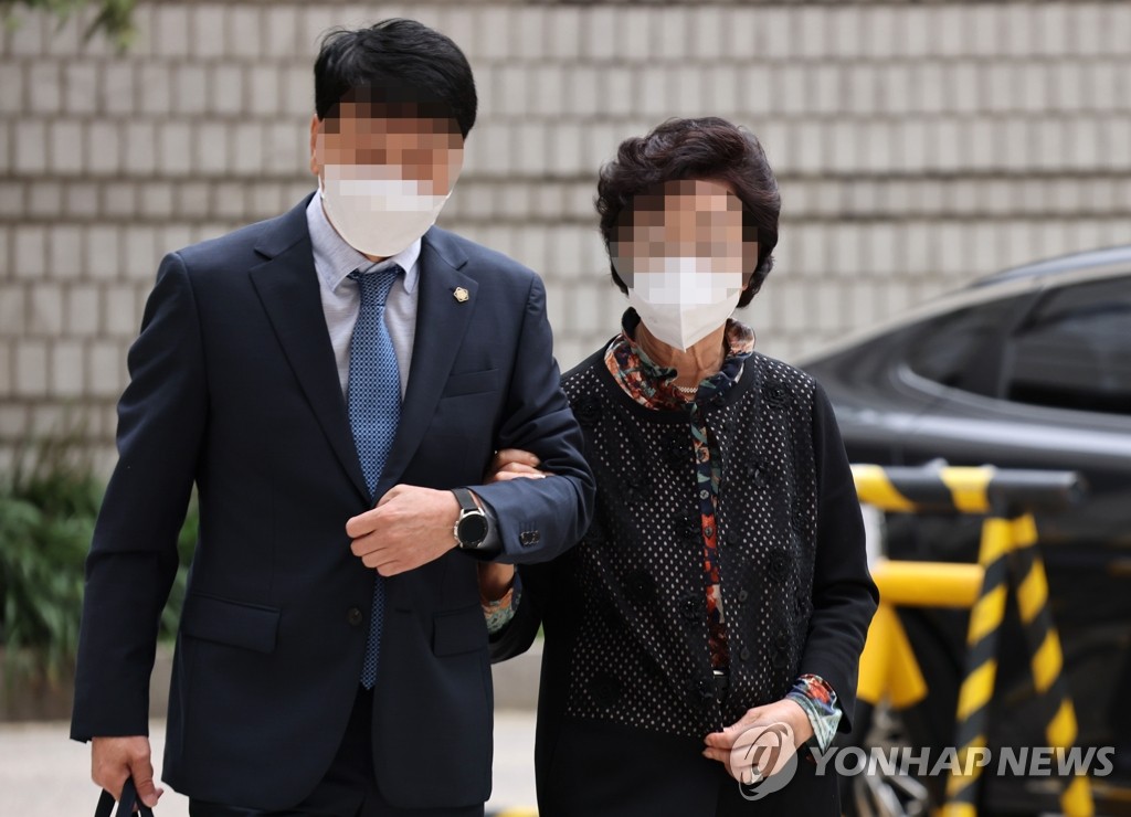 The mother-in-law (R) of Yoon Seok-youl, the presidential nominee of the main opposition People Power Party, enters Seoul High Court on Sept. 28, 2021, to attend a hearing. (Yonhap)