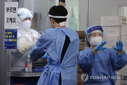 Des membres du personnel médical sont en pleine préparation au centre de dépistage du nouveau coronavirus (Covid-19) installé dans le quartier de Songpa à Séoul, le jeudi 7 octobre 2021. Les autorités ont rapporté 2.427 nouvelles contaminations le même jour.