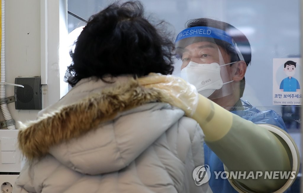 Ahn Cheol-soo, the presidential candidate of the minor opposition People's Party, takes a swab sample at a coronavirus testing center in Seoul, on Feb. 19, 2022, as he resumed public activities with the volunteer work after a pause due to the accidental deaths of two campaign workers earlier this week. (Pool photo) (Yonhap)