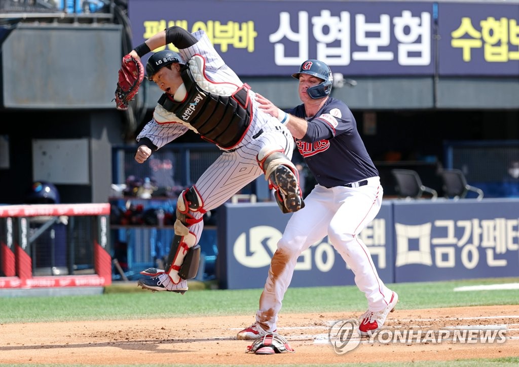 DJ Peters of the Lotte Giants (R) scores against the LG Twins during the top of the second inning of a Korea Baseball Organization preseason game at Jamsil Baseball Stadium in Seoul on March 27, 2022. (Yonhap)
