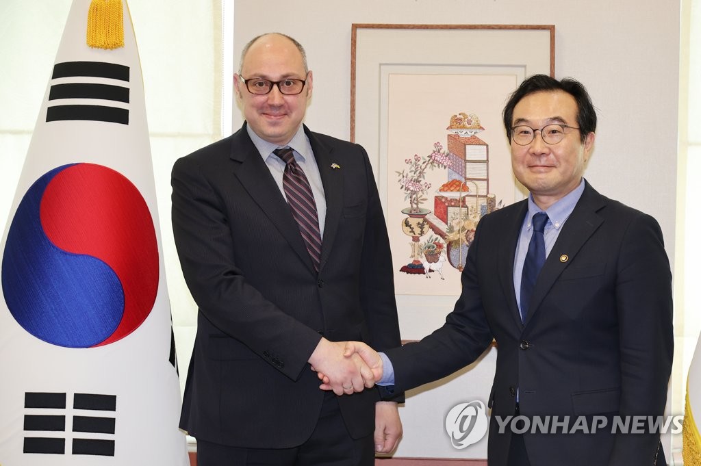 South Korean Second Vice Foregin Minister Lee Do-hoon (R) shakes hands with Ukrainian Deputy Foreign Minister Dmytro Senik during their meeting at Seoul's foreign ministry on June 7, 2022. (Yonhap)