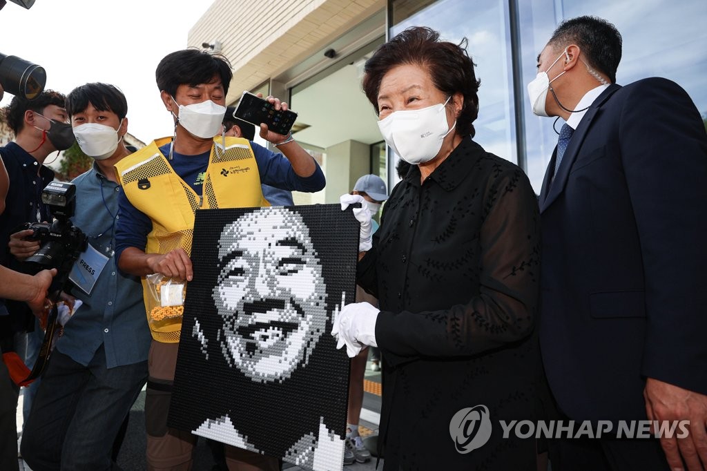 노무현 전 대통령 그림 들고 웃는 권양숙 여사