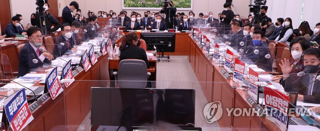 '야당탄압 규탄한다!' 팻말과 '부패척결 민생국감' 팻말 붙은 외통위