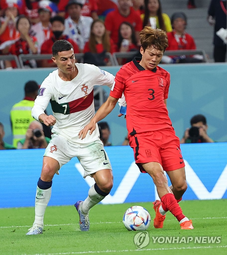 Kim Jin-su of South Korea (R) tries to hold off Cristiano Ronaldo of Portugal during the teams' Group H match at the FIFA World Cup at Education City Stadium in Al Rayyan, west of Doha, on Dec. 2, 2022. (Yonhap)