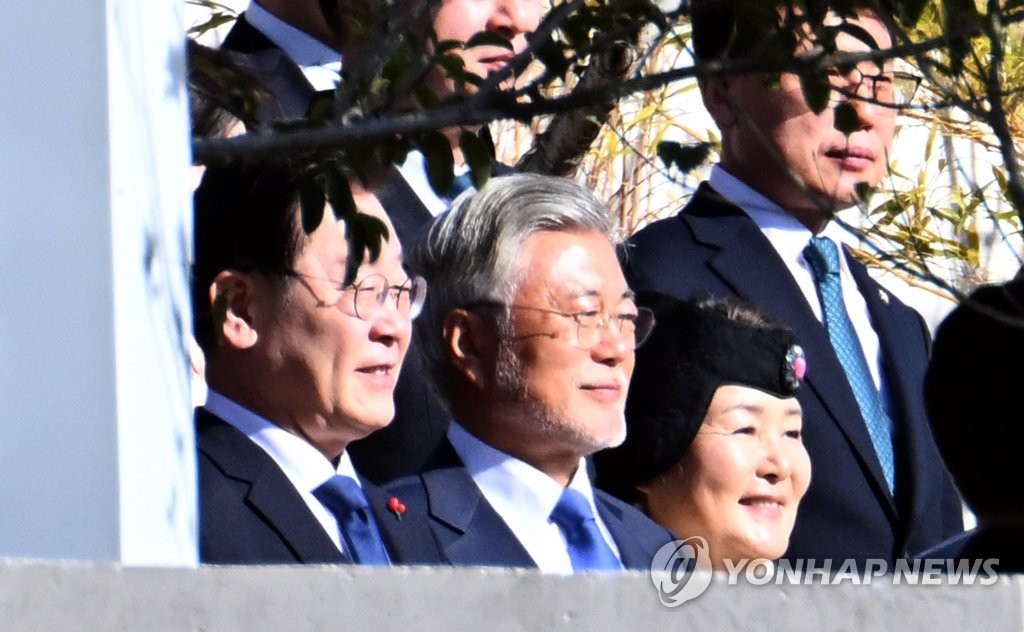 Former President Moon Jae-in (C) and Lee Ja-myung, the leader of the main opposition Democratic Party, pose for a photo at Moon's retirement home in Yangsan, about 310 kilometers southeast of Seoul, on Jan. 2, 2023. (Pool photo) (Yonhap)