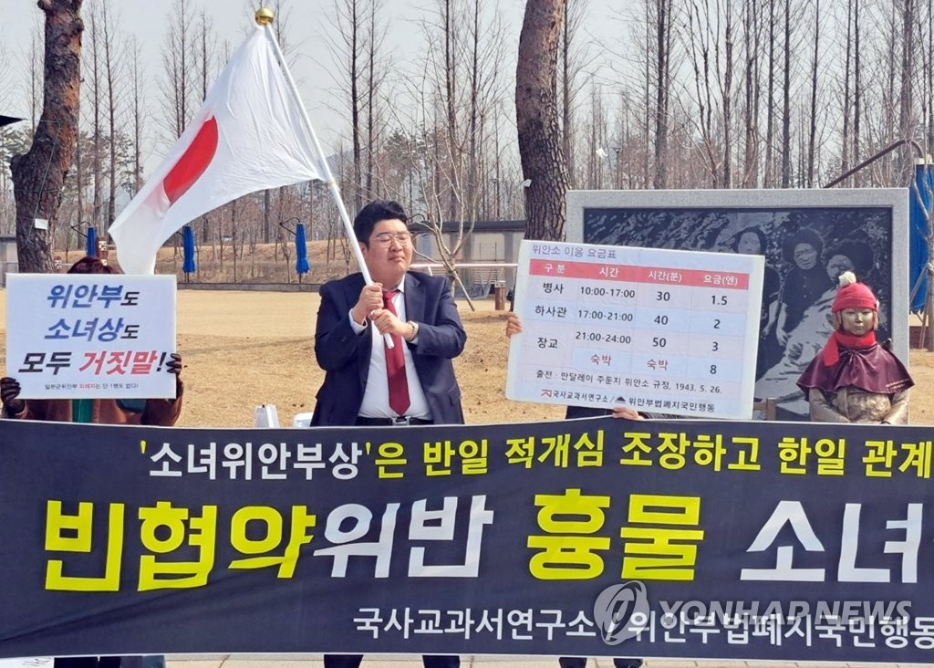 This March 7, 2023, file photo shows a man waving a Japanese flag at a rally calling for the removal of a statue of a girl symbolizing victims of Japan's wartime sexual slavery in the central city of Sejong, 112 kilometers south of Seoul. The man earlier drew criticism over hanging a Japanese flag on the March 1 Independence Movement Day this year. (Pool photo) (Yonhap)