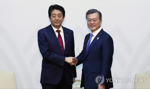 2月9日，在江原道龙平度假村，韩国总统文在寅（右）与日本首相安倍晋三举行首脑会谈。（韩联社）
