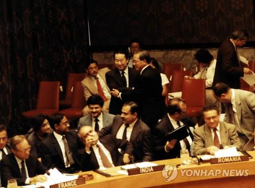 资料图片：1991年9月17日，在联合国总部，韩朝加入联合国成定局后，韩国大使卢昌熹（右）和朝鲜驻联合国大使朴吉渊在安理会会场握手相互祝贺。 韩联社
