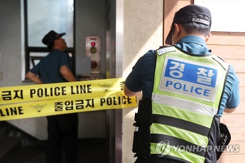 A police officer places yellow police tape in front of the office of renowned baseball commentator Ha Il-sung in Seoul on Sept. 8, 2016, after Ha, 67, was found dead there on the same day. The apparent suicide occurred just a few months after he was indicted over allegations of fraud. (Yonhap)