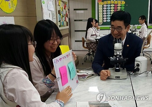 South Korean Education Minister Lee Joon-sik (far R) talks with students at Daedong Women's Middle School in Hoengseong, 137 kilometers northeast of Seoul, on Sept. 30, 2016, as he attends a class that is part of a test-free semester program conducted by the school. (Yonhap)