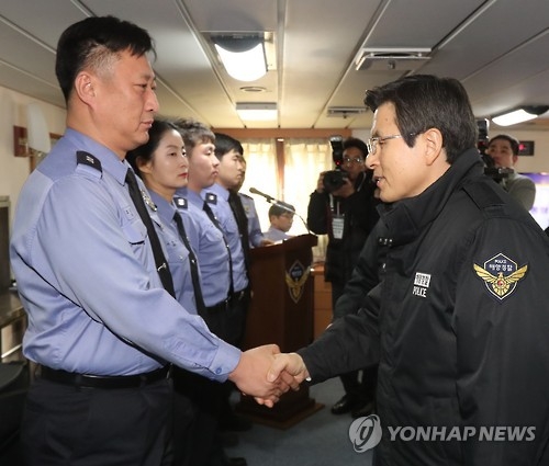Acting President and Prime Minister Hwang Kyo-ahn shakes hands with a Coast Guard officer during his visit to a patrol boat at a pier in Incheon, west of Seoul, on Jan. 16, 2017. (Yonhap)