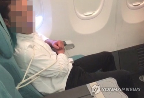 This photo provided by Korean Air shows a 35-year-old South Korean passenger tied to his seat following a violent outburst toward other passengers and flight attendants on a Korean Air flight from Vietnam to South Korea on Dec. 20, 2016. (Yonhap)