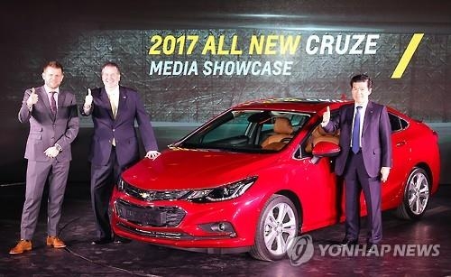 James Kim (R), president and CEO of GM Korea, poses for a picture after introducing the all new Chevrolet Cruze compact car in a media showcase in Seoul on Jan. 17, 2017. (Yonhap)