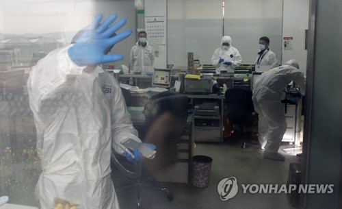 Police conduct an on-site inspection of a bank branch of the National Agricultural Cooperative Federation in the southeastern city of Gyeongsan on April 20, 2017, after an unidentified armed man escaped from the branch with a sack full of tens of millions of won. (Yonhap)