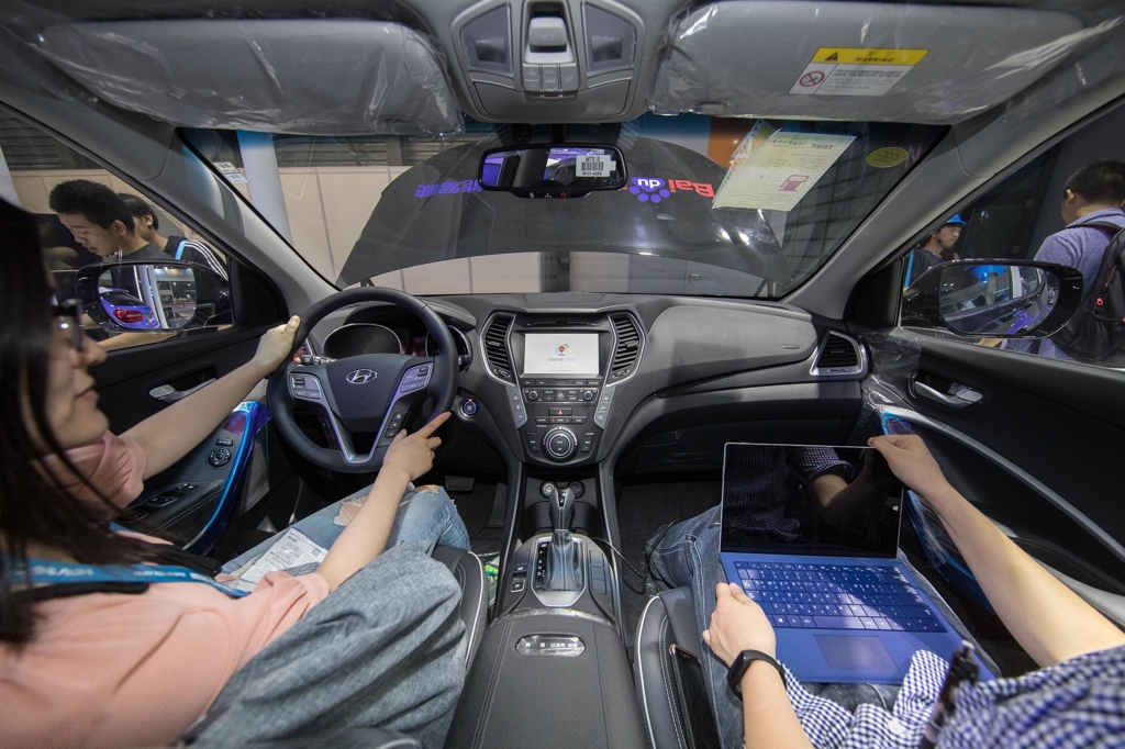 In this photo taken on June 7, 2017, and provided by Hyundai Motor Co., Chinese consumers test the navigation and voice recognition systems in a Santa Fe Tucson SUV displayed at the CES ASIA 2017 in Shanghai. (Yonhap)