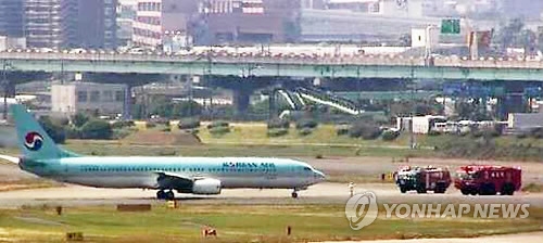 This captured image from Japan's largest broadcaster NHK shows fire trucks and Korean Air Line's B737-900 jet at Fukuoka airport after smoke was detected in the cockpit five minutes before landing on June 9, 2017. (Yonhap) 