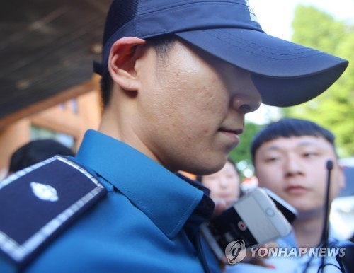 South Korean singer and actor T.O.P of boy band BIGBANG, who is serving his mandatory military service as a conscripted policeman, leaves his workplace in Seoul surrounded by reporters questioning his marijuana charges on June, 5, 2017. (Yonhap)