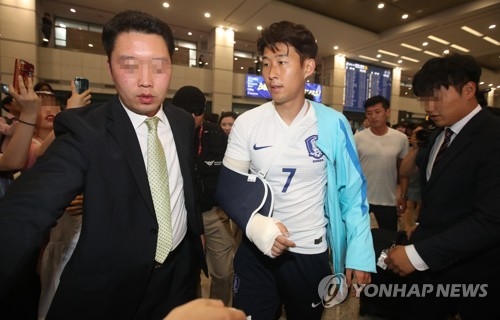 South Korean football player Son Heung-min (C) returns home on June 14, 2017, from a 3-2 loss to Qatar in a World Cup qualifier in Doha. Son broke his right forearm in a fall during the match. (Yonhap)