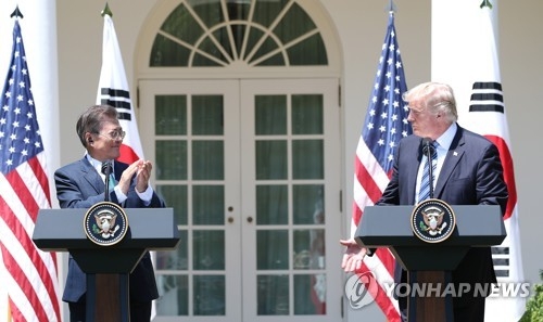 South Korean President Moon Jae-in (L) claps after listening to remarks from U.S. President Donald Trump on the outcome of their bilateral summit held at the White House on June 30, 2017. (Yonhap)