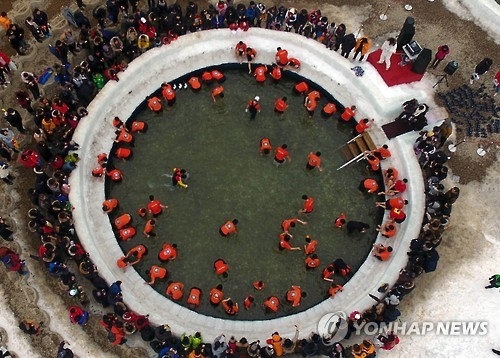 This 2017 file photo shows visitors catching "sancheoneo," a type of mountain trout, with bare hands during the annual Hwacheon Sancheoneo Ice Festival in Hwacheon, some 120 kilometers northeast of Seoul. (Yonhap)
