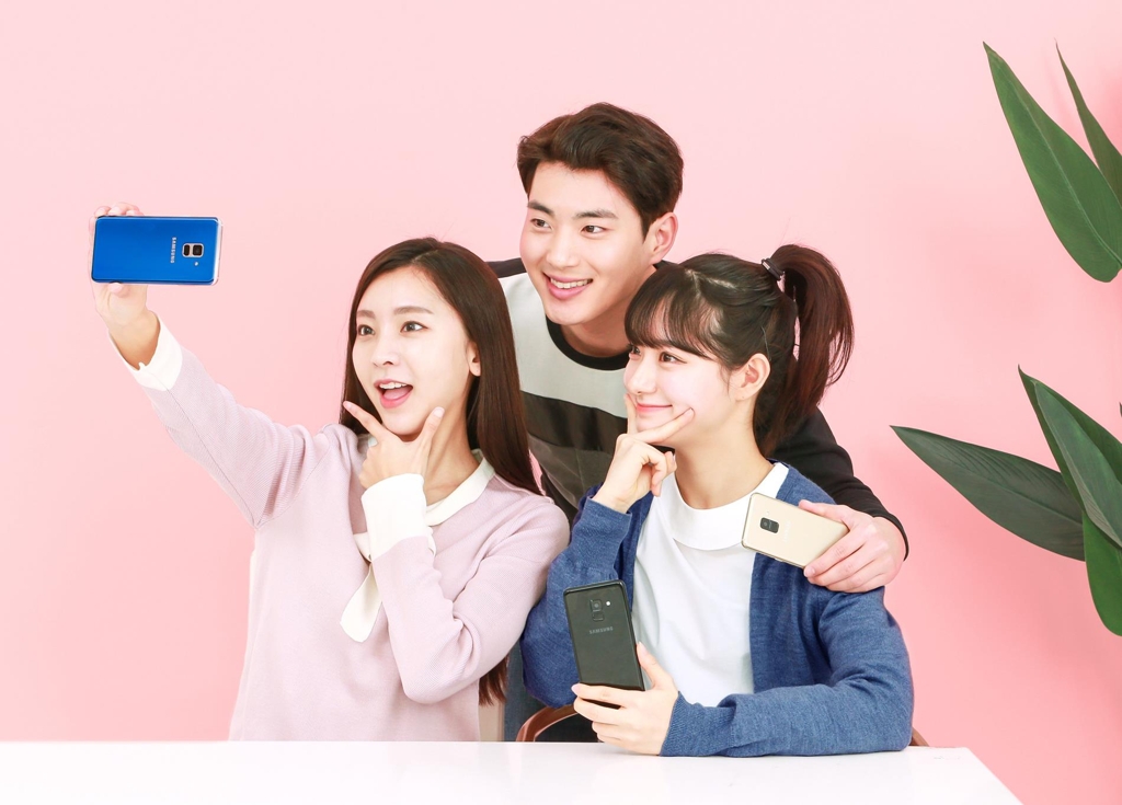 Models pose with the Galaxy A8 smartphones in this photo released by Samsung Electronics Co. on Jan. 5, 2018. (Yonhap)