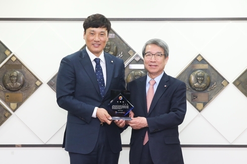 In this photo provided by the Korea Baseball Organization (KBO), retired star Lee Seung-yuop (L), the KBO's career home runs leader, and KBO Commissioner Chung Un-chan pose with a plaque appointing Lee as an honorary ambassador for the KBO. (Yonhap)