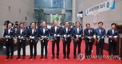 Paik Un-gyu, Minister of Trade, Industry and Energy (5th from L), and Kim Jong-kap, CEO of the state-run Korea Electric Power Corp. (KEPCO) attend a ribbon-cutting ceremony for a nuclear export support center held at the KEPCO's Seoul office on July 2, 2018, in this photo provided by the ministry. (Yonhap) 