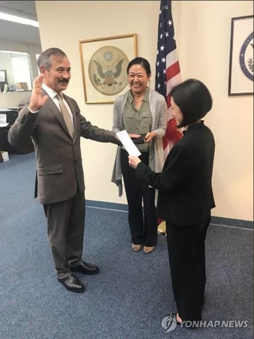 New U.S. Ambassador to South Korea Harry Harris (L) takes an oath at the State Department in Washington on June 29, 2018 in this photo posted on its Twitter account. (Yonhap)