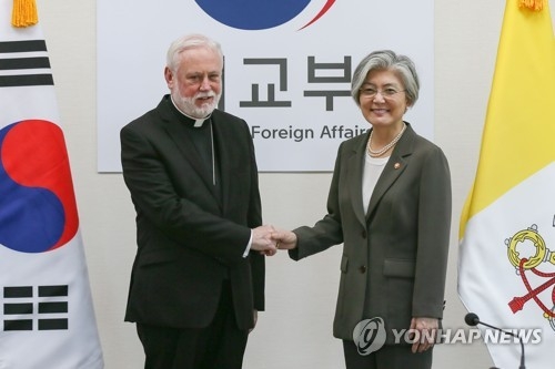 South Korean Foreign Minister Kang Kyung-wha (R) shakes hands with Archbishop Paul Richard Gallagher, the Vatican's secretary for relations with states, before their talks in Seoul on July 6, 2018, in this photo provided by Seoul's foreign ministry. (Yonhap)