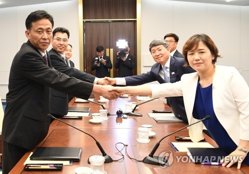 This photo, provided by South Korea's unification ministry on July 4, 2018, shows South and North Korean officials shaking hands before holding working-level talks on forestry cooperation. (Yonhap)