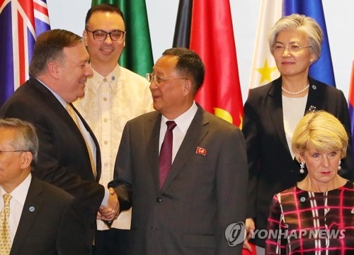 U.S. Secretary of State Mike Pompeo (L) shakes hands with North Korean Foreign Minister Ri Yong-ho at a photo session of the ASEAN Regional Forum in Singapore on Aug. 4, 2018. (Yonhap)